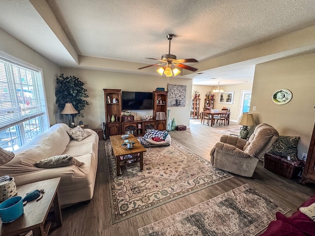 living room featuring a textured ceiling, ceiling fan, wood finished floors, and baseboards