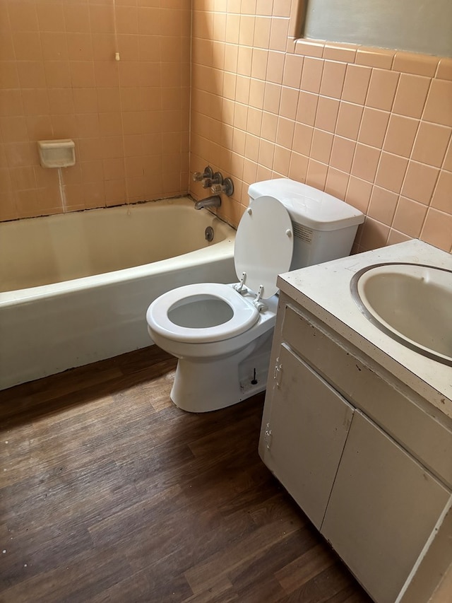 1511 E Moore St, Valdosta, GA 31601 - full bath featuring vanity, tile walls, wood finished floors, and washtub / shower combination