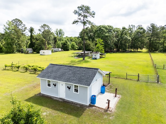 exterior space featuring an attached garage, fence, and an outbuilding