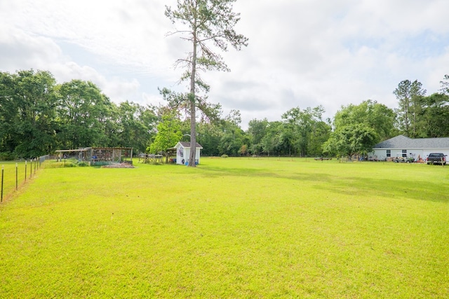 view of yard with fence, an outdoor structure, and a shed
