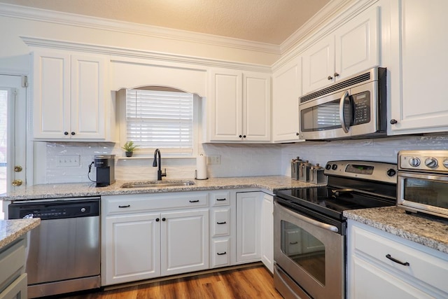 kitchen featuring a sink, wood finished floors, white cabinetry, and stainless steel appliances