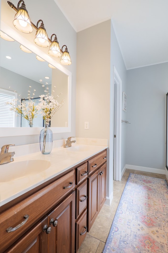 bathroom featuring double vanity, tile patterned flooring, baseboards, and a sink