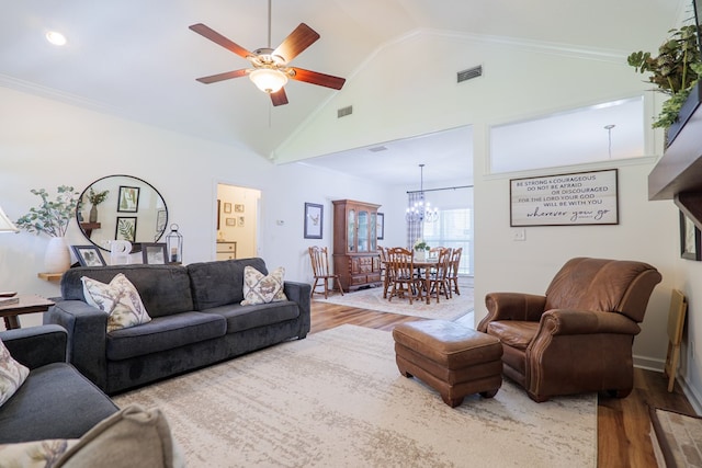 living room featuring visible vents, crown molding, ceiling fan with notable chandelier, wood finished floors, and high vaulted ceiling