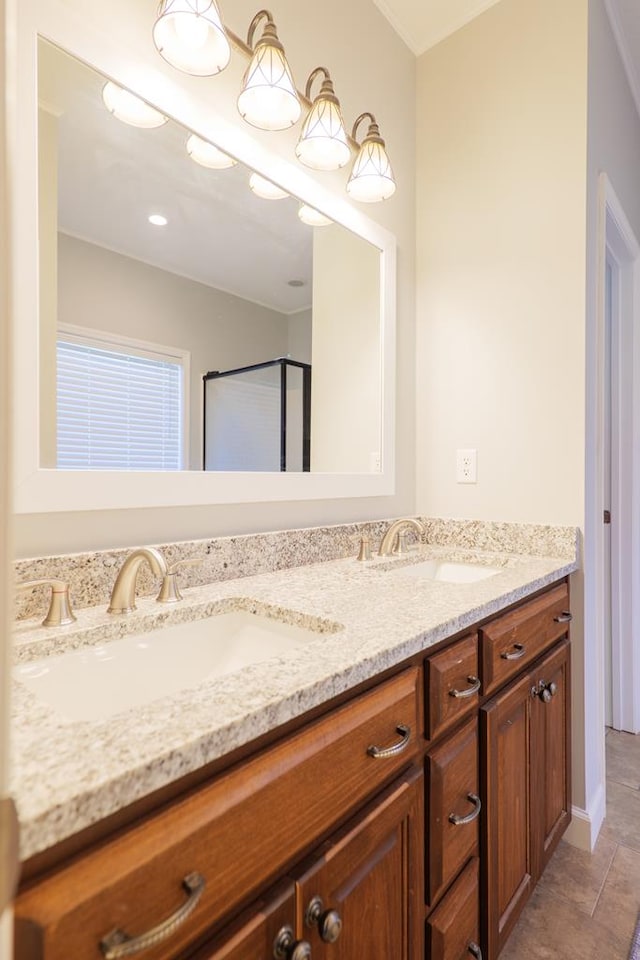 full bathroom featuring a sink, baseboards, a shower with shower door, and double vanity