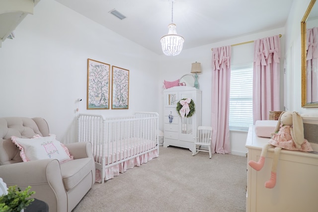 bedroom featuring a crib, a notable chandelier, light colored carpet, and visible vents