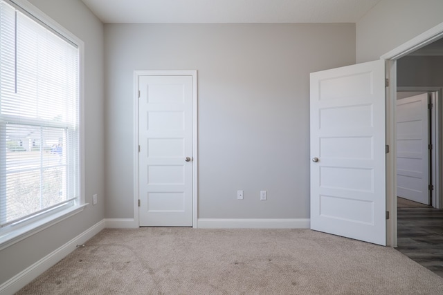 unfurnished bedroom with light colored carpet