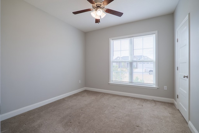 carpeted spare room featuring ceiling fan