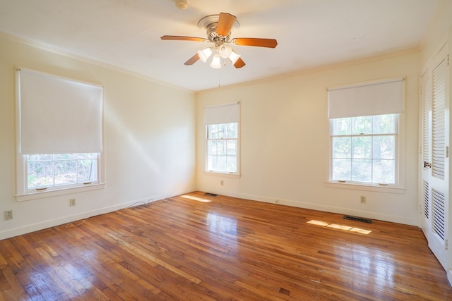 unfurnished room with hardwood / wood-style floors, crown molding, and ceiling fan