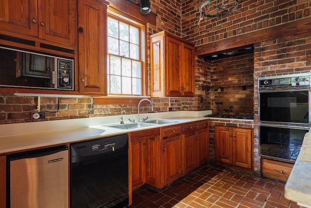 kitchen featuring sink, black appliances, and brick wall