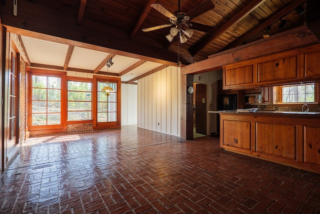 kitchen featuring vaulted ceiling with beams, ceiling fan, kitchen peninsula, hanging light fixtures, and wood ceiling