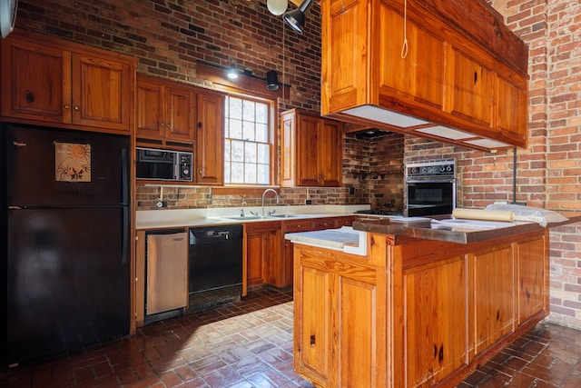 kitchen with sink, brick wall, black appliances, and a kitchen island