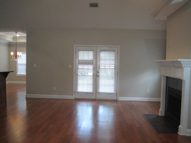 3745 Old Vine Way, Valdosta, GA 31605 - unfurnished living room featuring a tiled fireplace, a chandelier, dark wood finished floors, baseboards, and french doors