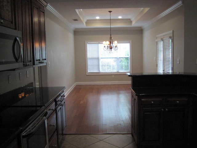3745 Old Vine Way, Valdosta, GA 31605 - kitchen with stainless steel microwave, electric range, ornamental molding, a chandelier, and a tray ceiling