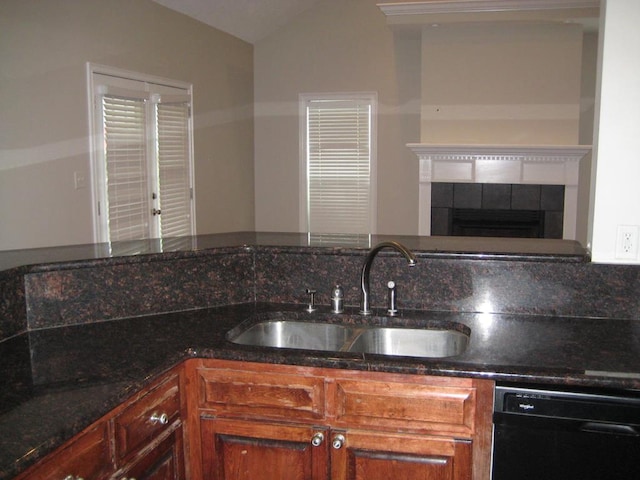 3745 Old Vine Way, Valdosta, GA 31605 - kitchen featuring a sink, dishwasher, dark stone countertops, vaulted ceiling, and a fireplace