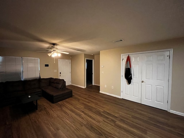 living room featuring ceiling fan and dark hardwood / wood-style flooring