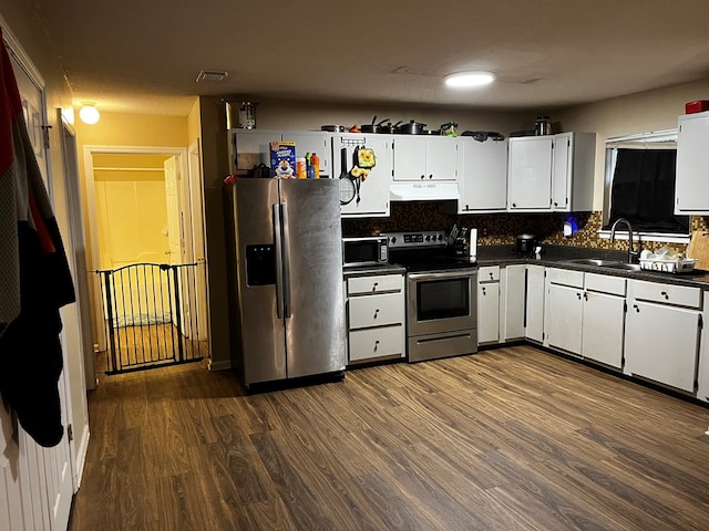 kitchen featuring sink, appliances with stainless steel finishes, tasteful backsplash, dark hardwood / wood-style flooring, and white cabinetry