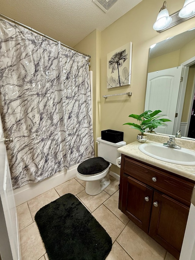 3650 Tupelo Rd, Valdosta, GA 31605 - full bath featuring vanity, toilet, shower / tub combo with curtain, tile patterned flooring, and a textured ceiling