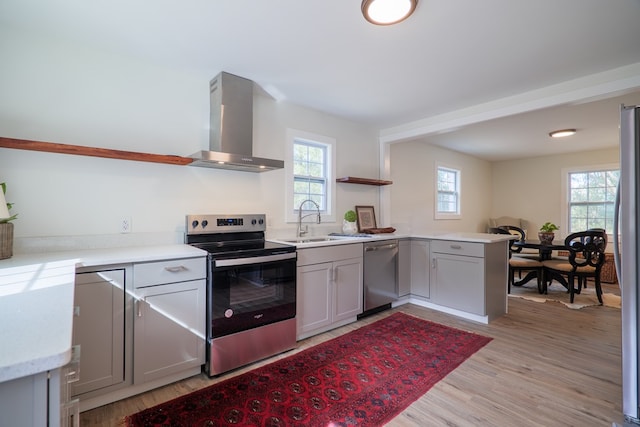 6041 NE Edmundson Rd, Hahira, GA 31632 - kitchen with appliances with stainless steel finishes, wall chimney exhaust hood, a sink, open shelves, and a peninsula