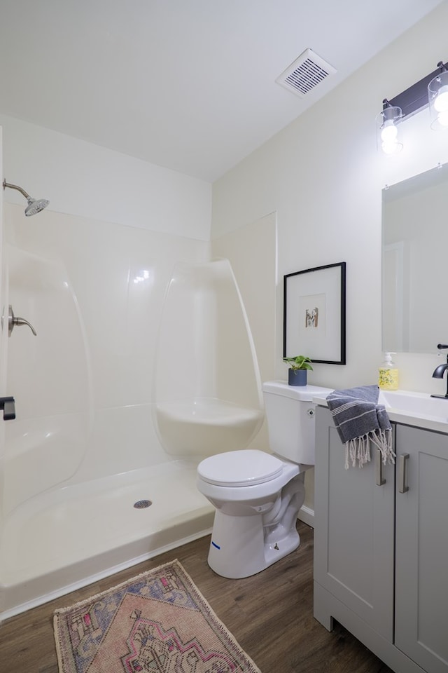 6041 NE Edmundson Rd, Hahira, GA 31632 - bathroom featuring vanity, wood finished floors, toilet, and a shower