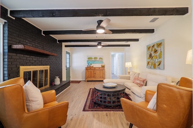 6041 NE Edmundson Rd, Hahira, GA 31632 - living room with a fireplace, light wood-type flooring, beamed ceiling, and a ceiling fan