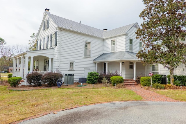 view of front of home with a porch, central AC unit, and a front lawn