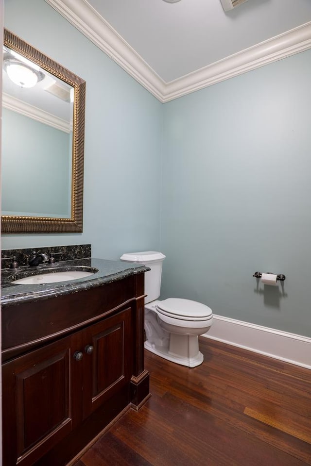 bathroom with vanity, hardwood / wood-style flooring, toilet, and ornamental molding