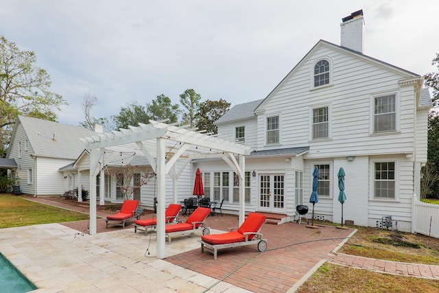 back of property with a patio area, a pergola, and french doors