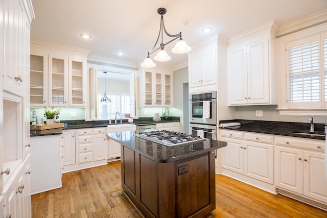 kitchen featuring white cabinets, light wood-type flooring, a center island, and stainless steel appliances