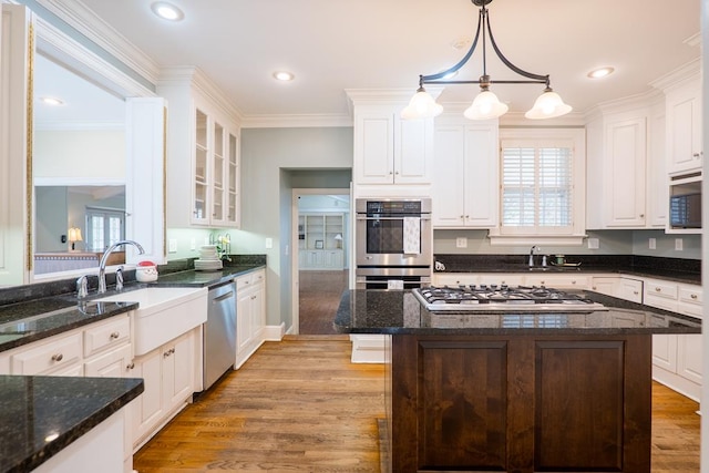 kitchen with white cabinets, appliances with stainless steel finishes, and light hardwood / wood-style flooring