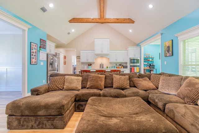 living room featuring vaulted ceiling with beams and light wood-type flooring