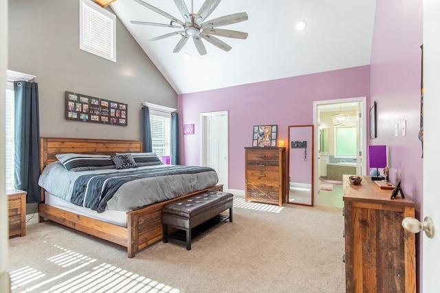 bedroom featuring light colored carpet, ceiling fan, connected bathroom, and high vaulted ceiling