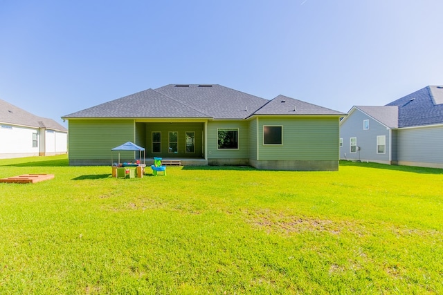 back of property featuring a yard