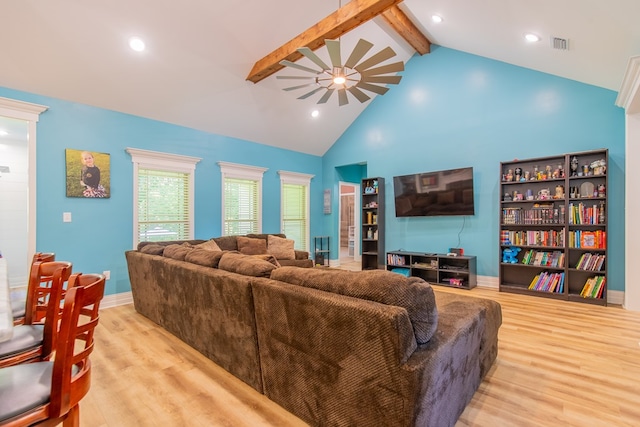 living room featuring ceiling fan, high vaulted ceiling, light wood-type flooring, and beam ceiling