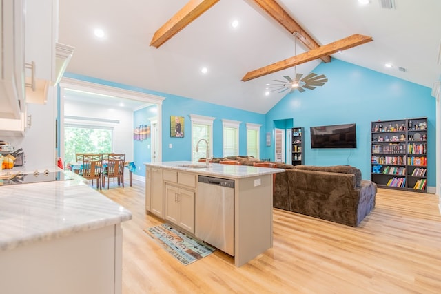 kitchen with a kitchen island with sink, light stone counters, beamed ceiling, and dishwasher