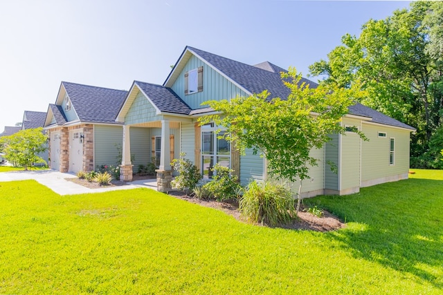 craftsman-style house featuring a garage, a front lawn, and covered porch