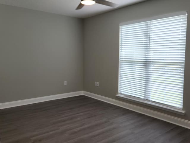 spare room with dark hardwood / wood-style floors and ceiling fan