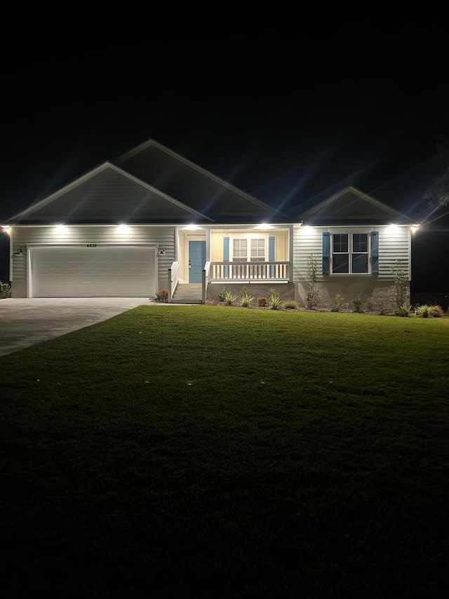 view of front facade featuring a garage, covered porch, and a lawn