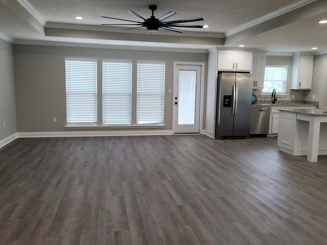 unfurnished living room with dark hardwood / wood-style floors, ornamental molding, and a tray ceiling