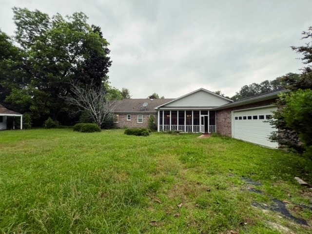 view of yard with a garage and a sunroom