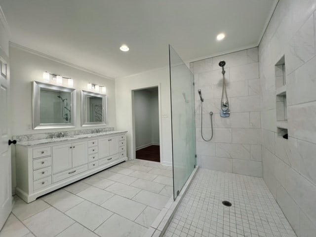 bathroom featuring tile patterned floors, vanity, tiled shower, and crown molding