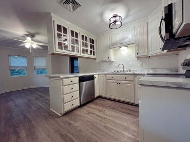 kitchen featuring hardwood / wood-style floors, white cabinets, sink, appliances with stainless steel finishes, and kitchen peninsula