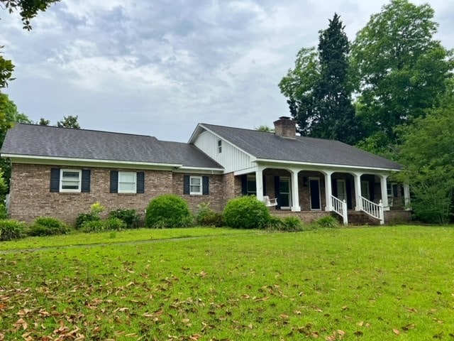 ranch-style home with a porch and a front lawn