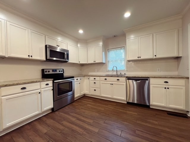 kitchen with sink, white cabinets, dark hardwood / wood-style flooring, and stainless steel appliances