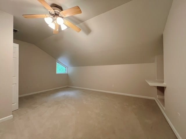 bonus room featuring ceiling fan, light colored carpet, and lofted ceiling