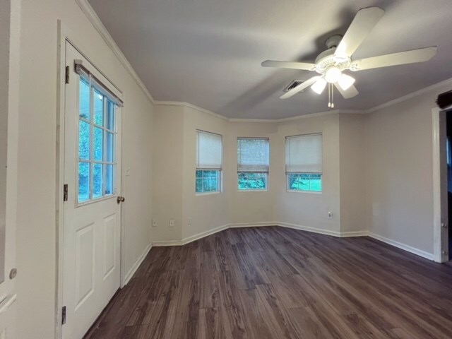 entrance foyer with ceiling fan, crown molding, and dark wood-type flooring