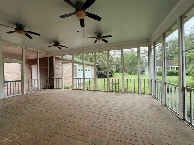 unfurnished sunroom featuring ceiling fan