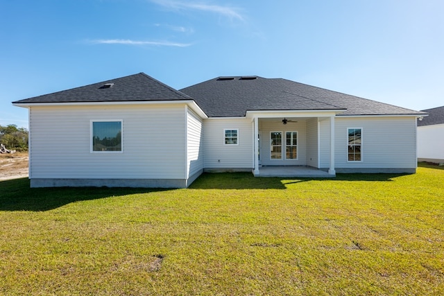 back of property with a lawn, ceiling fan, and a patio