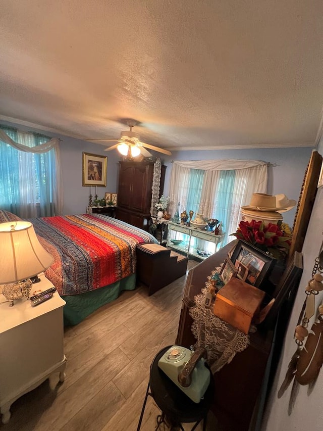 bedroom with wood-type flooring, ceiling fan, and a textured ceiling