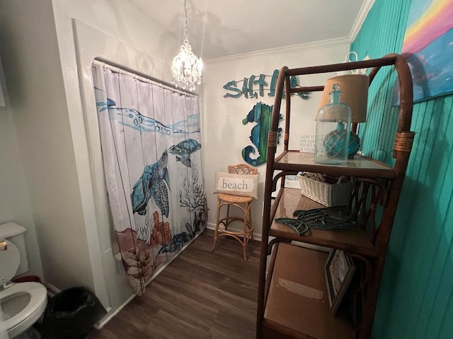 bathroom featuring wood-type flooring, ornamental molding, a notable chandelier, toilet, and a shower with curtain