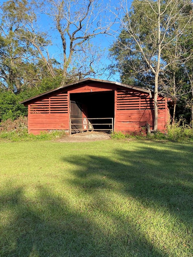 view of outbuilding featuring a lawn